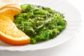 Japanese cuisine. Seaweed salad with orange in white plate Royalty Free Stock Photo