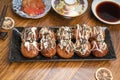 Japanese cuisine Takoyaki octopus balls with takoyaki sauce on wooden table, Traditional Japanese food. Royalty Free Stock Photo