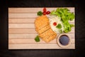 Japanese deep fried breaded pork cutlet served with shredded cabbage and tonkatsu sauce on wooden plate and black background Royalty Free Stock Photo