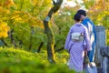 Japanese Destinations. Couple of Japanese Geishas in Traditional Silk Kimonos Posing in Garden of Kyoto City, Japan