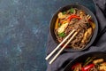 Japanese dish buckwheat soba noodles with chicken and vegetables carrot, bell pepper and green beans in grey bowl, top view, copy Royalty Free Stock Photo