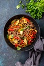 Japanese dish buckwheat soba noodles with chicken and vegetables carrot, bell pepper and green beans in wok on dark blue Royalty Free Stock Photo
