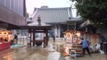 Japanese elderlies in rain purifying their soul with incense smoke in the Koganji temple of Sugamo.