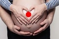 Japanese family concept. Man embracing pregnant woman belly and heart with flag of  Japan colors closeup Royalty Free Stock Photo