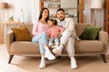 Japanese Father, Mother And Daughter Sitting On Couch At Home Royalty Free Stock Photo