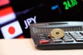 Japanese five Yen coins JPY on white floor with black calculator and digital board of currency exchange money background. Royalty Free Stock Photo