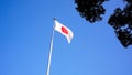 Japanese flag waving in wind with blue sky. Japan banner blowing, soft silk Royalty Free Stock Photo