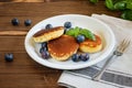 Japanese fluffy pancakes with bluberries, thick souffle. Delicious breakfast on the white plate, on the wooden background