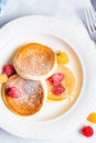 Japanese fluffy pancakes with raspberries in white plate, white background, top view. Japanese cuisine concept