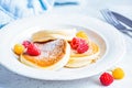 Japanese fluffy pancakes with raspberries in white plate, white background. Japanese cuisine concept