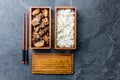 Japanese food. Chicken teriyaki with rice in wooden bento lunch box. slate background, top view. Royalty Free Stock Photo