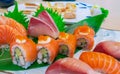 Japanese food combo set on white plate. Salmon sushi, sashimi, and nigiri on restaurant table. Fish meat sliced and Japan Royalty Free Stock Photo