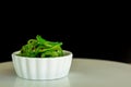 Japanese food concept. Fresh seaweed salad with sesame seeds in white bowl on black background Royalty Free Stock Photo