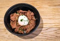 Japanese food Gyudon - beef on rice, topped with egg on wooden table