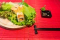 Japanese food restaurant platter set. Hand take roll. Set for two with chopsticks, ginger, soy, wasabi. Sushi at rustic wood backg Royalty Free Stock Photo