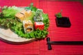 Japanese food restaurant platter set. Hand take roll. Set for two with chopsticks, ginger, soy, wasabi. Sushi at rustic wood backg Royalty Free Stock Photo