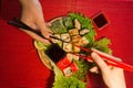 Japanese food restaurant platter set. Hand take roll. Set for two with chopsticks, ginger, soy, wasabi. Sushi at rustic wood backg Royalty Free Stock Photo