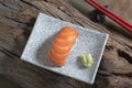 Japanese food salmon sushi in plate has chopsticks on wood background Royalty Free Stock Photo