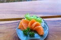 Japanese food sashimi salmon in black plate decoration with vegetable on wooden table. Royalty Free Stock Photo