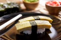 Japanese food tamago nigiri sushi on black plate