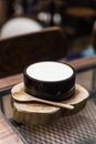 Japanese fusion dessert: White smooth milk pudding. Serve in a black ceramic bowl on timber with wooden spoon