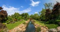 Japanese garden with canal and red bridge Royalty Free Stock Photo