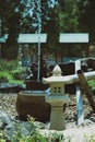 Japanese garden stone lamp and fountain in behind, Japanese garden style, vertical image view. Royalty Free Stock Photo