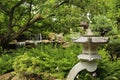 A Japanese garden with a stone lantern, Maple tree, shrubs, ferns and a stone waterfall at Rotary Botanic Gardens in Wisconsin