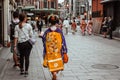 Japanese Geisha in a blue and yellow kimono walking down a street in Gion Kyoto Japan