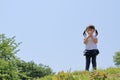 Japanese girl blowing dandelion seeds under the blue sky Royalty Free Stock Photo