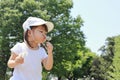 Japanese girl blowing dandelion seeds under the blue sky Royalty Free Stock Photo