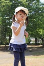 Japanese girl blowing dandelion seeds under the blue sky Royalty Free Stock Photo