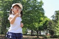 Japanese girl blowing dandelion seeds under the blue sky Royalty Free Stock Photo