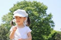 Japanese girl blowing dandelion seeds under the blue sky Royalty Free Stock Photo