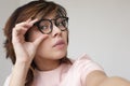 Japanese girl corrects glasses. She looks into the camera doubtfully Royalty Free Stock Photo