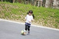 Japanese girl dribbling soccer ball Royalty Free Stock Photo