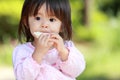 Japanese girl eating rice cracker Royalty Free Stock Photo