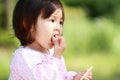 Japanese girl eating rice cracker Royalty Free Stock Photo