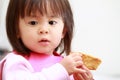 Japanese girl eating rice cracker Royalty Free Stock Photo