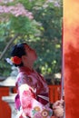 Japanese girl in Kimono dress stand and catch fabric rope to ringing the bell for bless at Shrine in Japan. Royalty Free Stock Photo