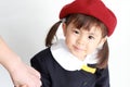 Japanese girl in kindergarten uniform clasping her mother`s hand Royalty Free Stock Photo