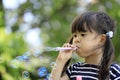 Japanese girl playing with bubble in the green Royalty Free Stock Photo