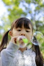 Japanese girl playing with bubble in the green Royalty Free Stock Photo