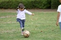 Japanese girl playing with soccer ball Royalty Free Stock Photo