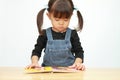 Japanese girl reading a picture book Royalty Free Stock Photo