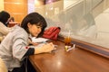 Japanese girl sitting inside a coffee shop.