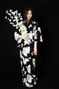 Japanese girl in traditional Japanese kimono, holds sprigs of ch