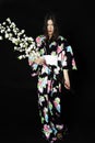 Japanese girl in traditional Japanese kimono, holds sprigs of ch