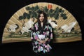 Japanese girl in traditional Japanese kimono, holds sprigs of ch