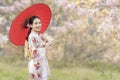 Japanese girl wearing a kimono holding a red umbrella. Beautiful Female wearing traditional japanese kimono with cherry blossom in